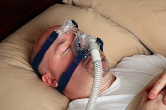 Man with sleep apnea using a CPAP machine